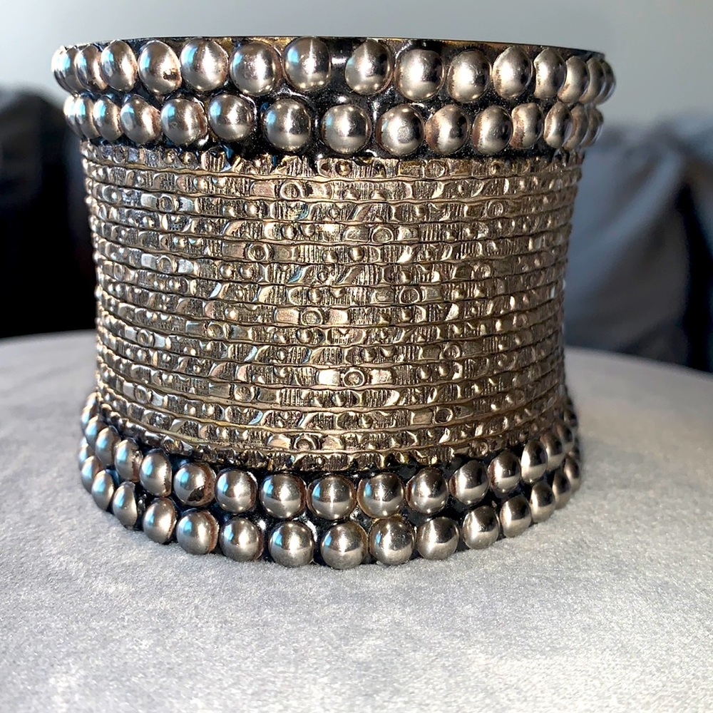 Brass bracelet with silvertone adorned metals.